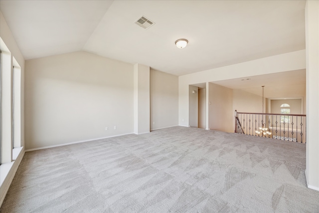 carpeted spare room with lofted ceiling