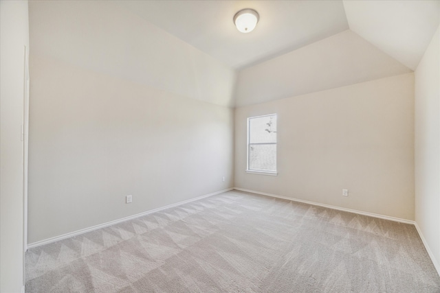 carpeted spare room with lofted ceiling