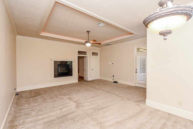 unfurnished living room with a raised ceiling, ceiling fan, a high end fireplace, and light colored carpet