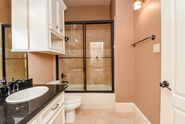 full bathroom featuring tile patterned flooring, vanity, toilet, and enclosed tub / shower combo