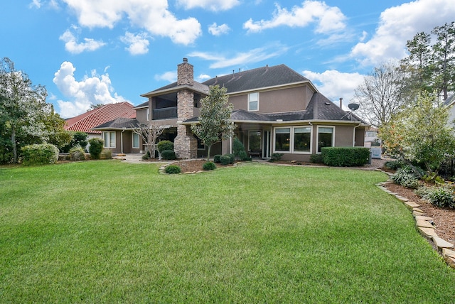 rear view of property featuring a lawn