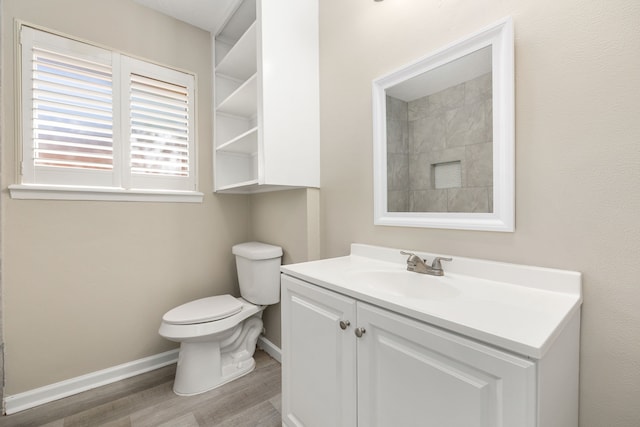 bathroom with hardwood / wood-style floors, vanity, and toilet