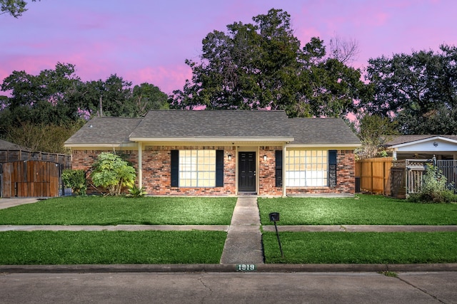 ranch-style home with a lawn