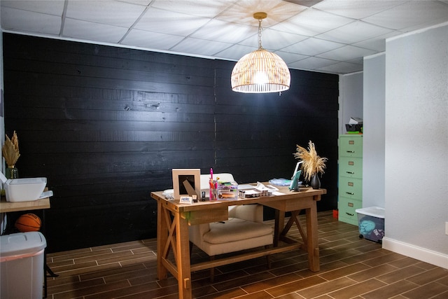 office area featuring wooden walls and dark wood-type flooring