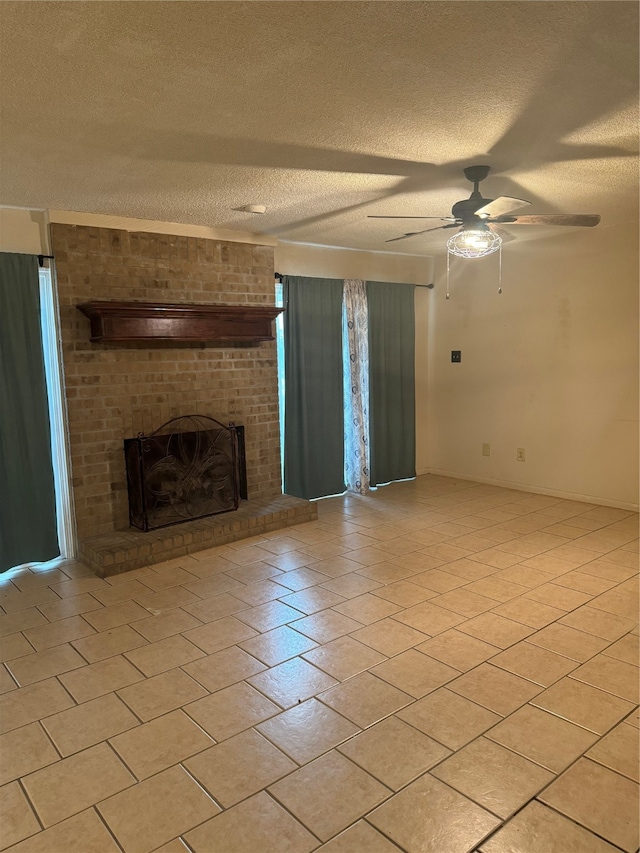 unfurnished living room with ceiling fan, a textured ceiling, and a brick fireplace