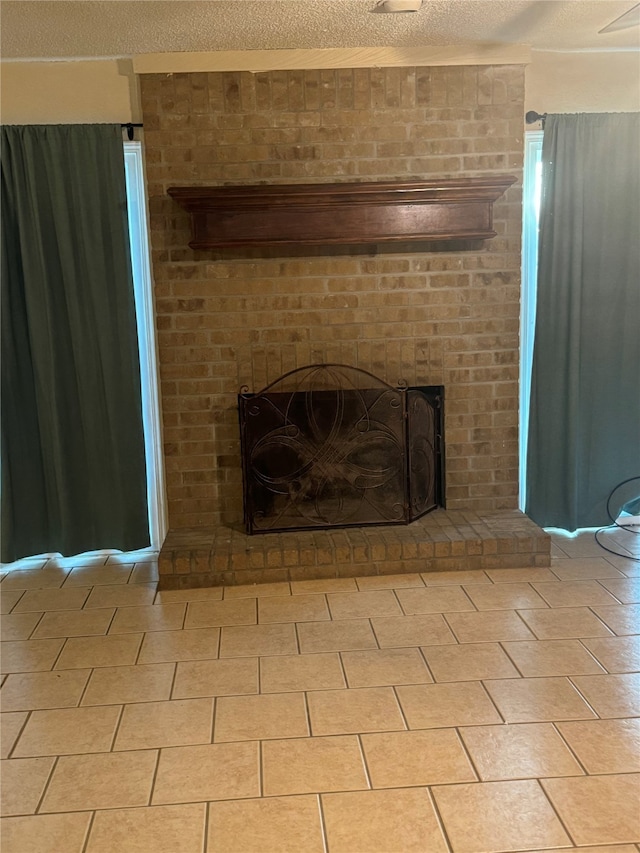 interior details featuring a textured ceiling and a brick fireplace