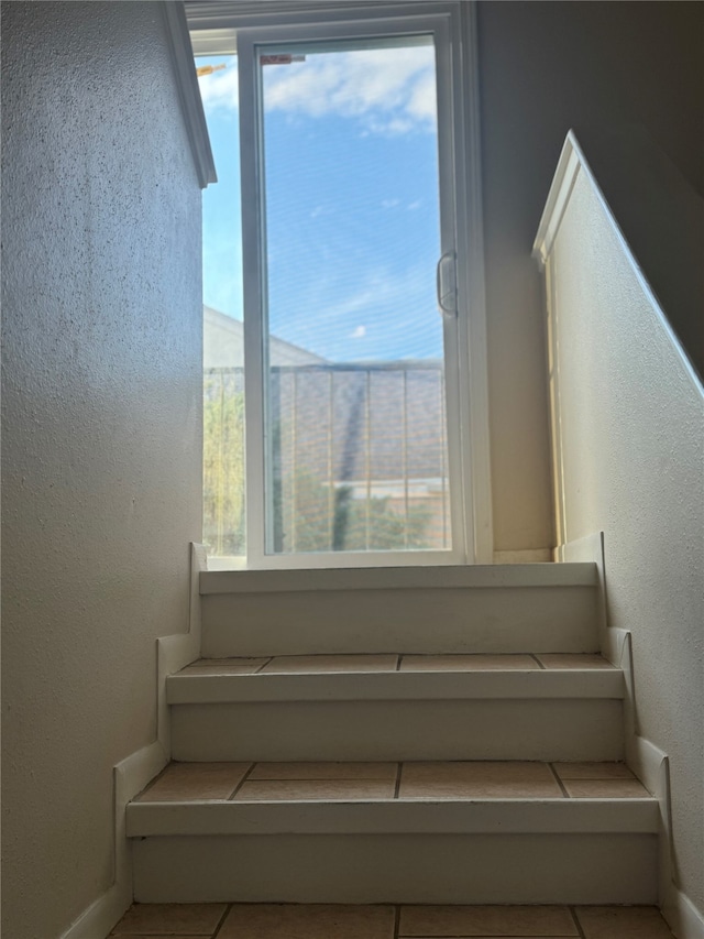 staircase featuring tile patterned flooring