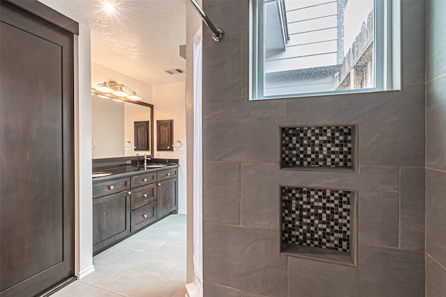 bathroom featuring a textured ceiling and vanity