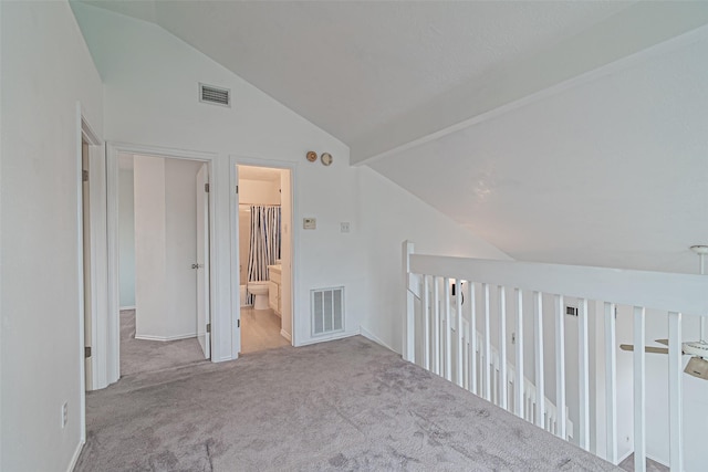 carpeted empty room featuring lofted ceiling