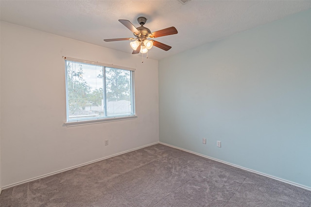 carpeted spare room featuring ceiling fan and a textured ceiling