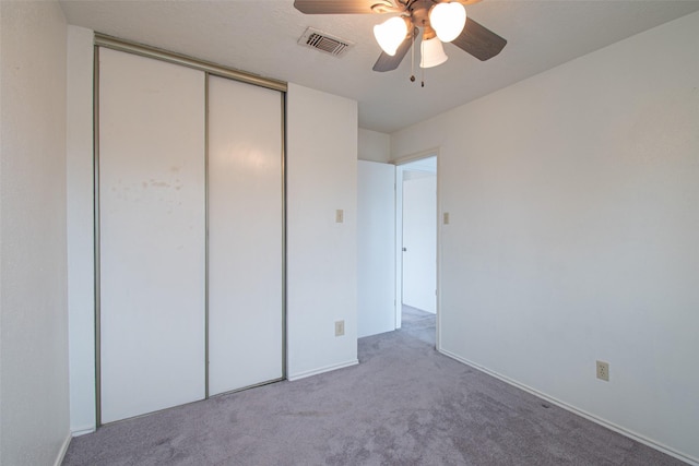 unfurnished bedroom featuring ceiling fan, carpet, and a closet