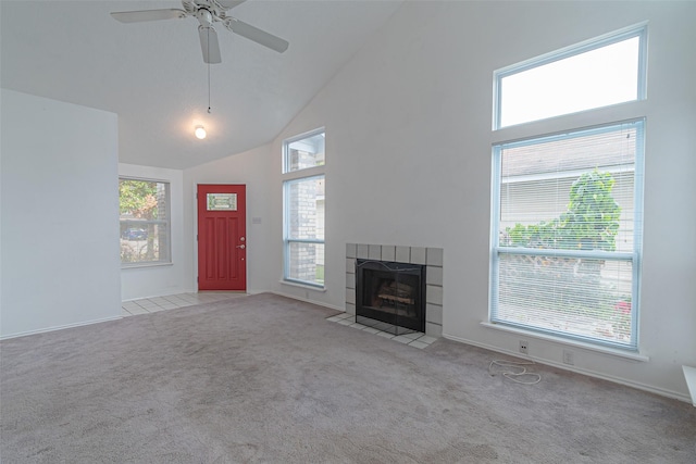 unfurnished living room featuring light carpet, high vaulted ceiling, a tiled fireplace, and ceiling fan