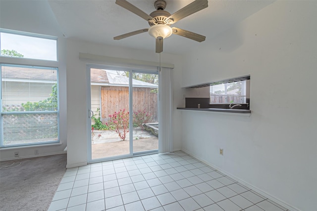 spare room with a healthy amount of sunlight, light tile patterned floors, and ceiling fan