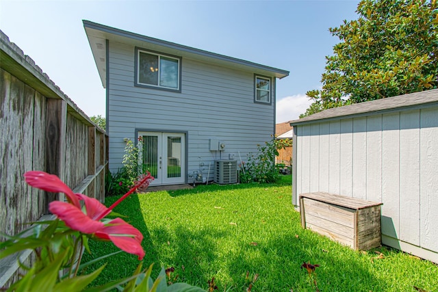 rear view of property featuring central AC, french doors, and a yard