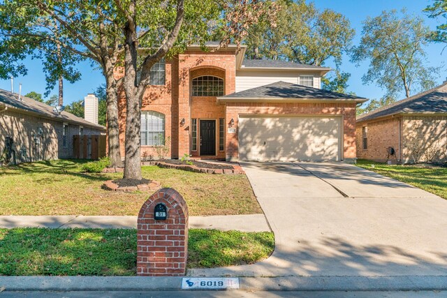 view of property featuring a front yard and a garage