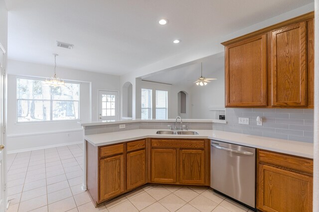 kitchen featuring sink, tasteful backsplash, stainless steel dishwasher, kitchen peninsula, and ceiling fan with notable chandelier