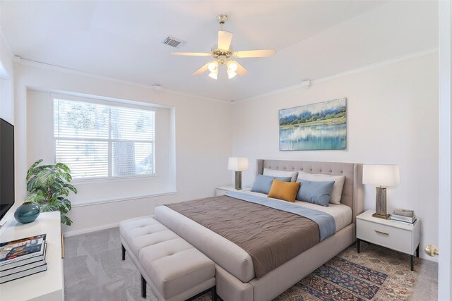 carpeted bedroom featuring ceiling fan and crown molding