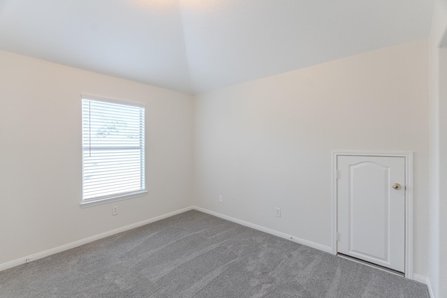 carpeted empty room featuring baseboards