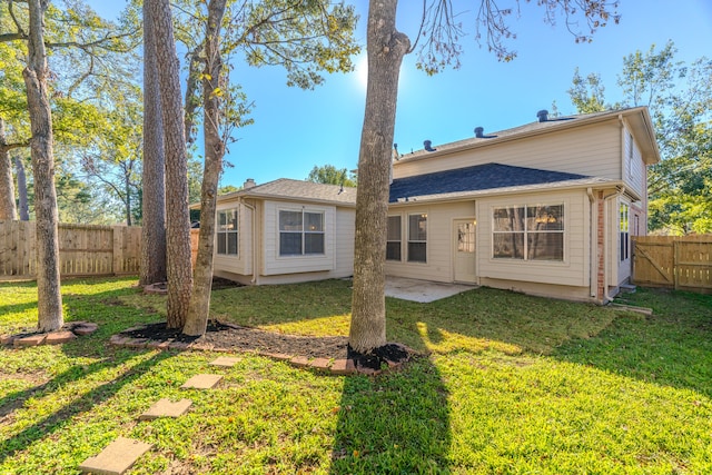 back of house with a yard and a patio