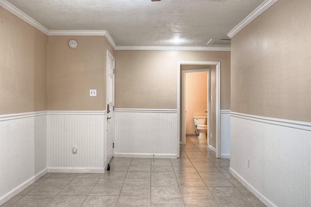 empty room featuring light tile patterned floors and ornamental molding