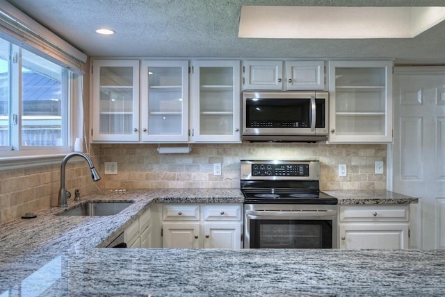 kitchen featuring sink, white cabinetry, stainless steel appliances, and tasteful backsplash