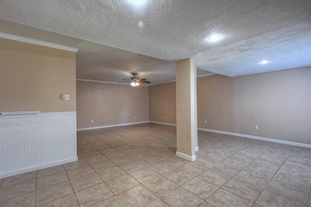 basement featuring ceiling fan, ornamental molding, and a textured ceiling