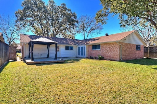 back of property featuring french doors, a deck, a gazebo, and a lawn