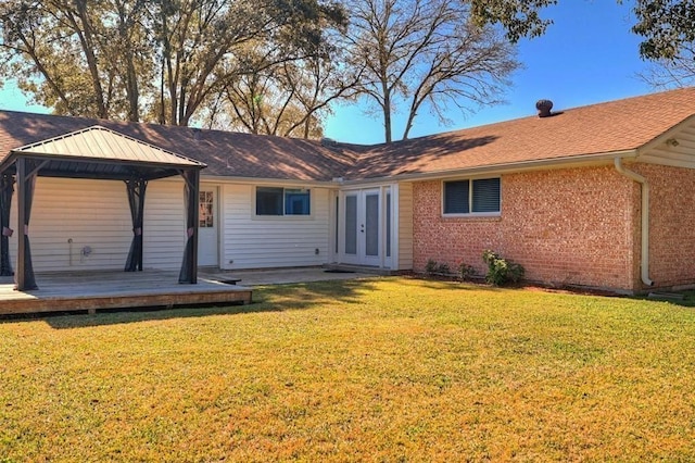 view of front facade featuring a front lawn, a gazebo, a wooden deck, and french doors