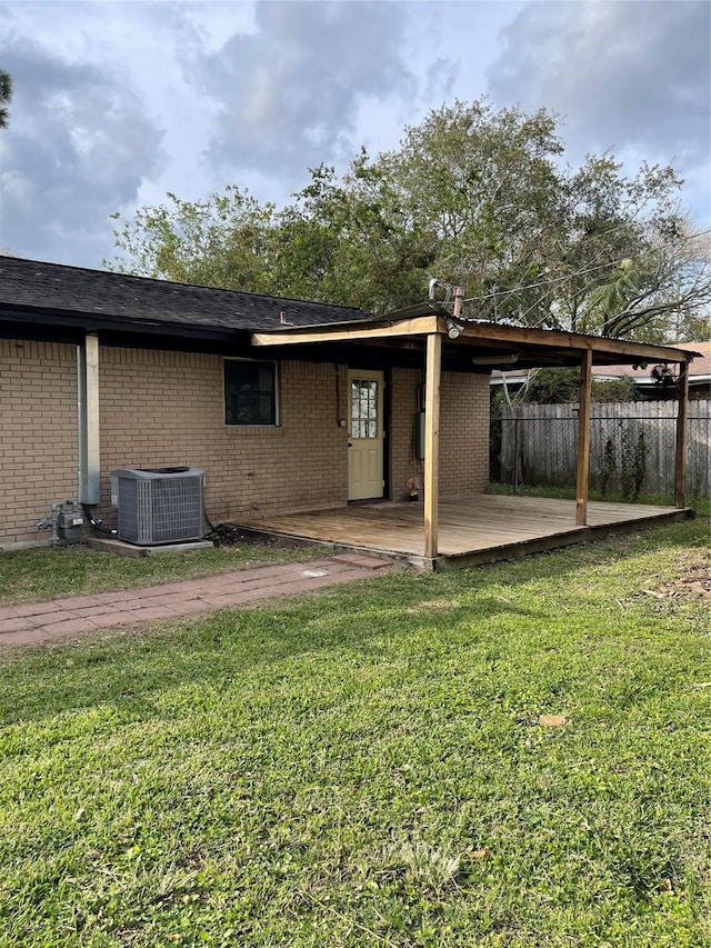 rear view of house featuring central AC and a yard