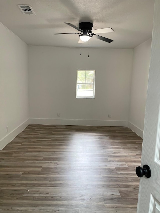 spare room with hardwood / wood-style floors and ceiling fan