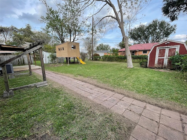 view of yard featuring a playground, central AC unit, and a storage unit