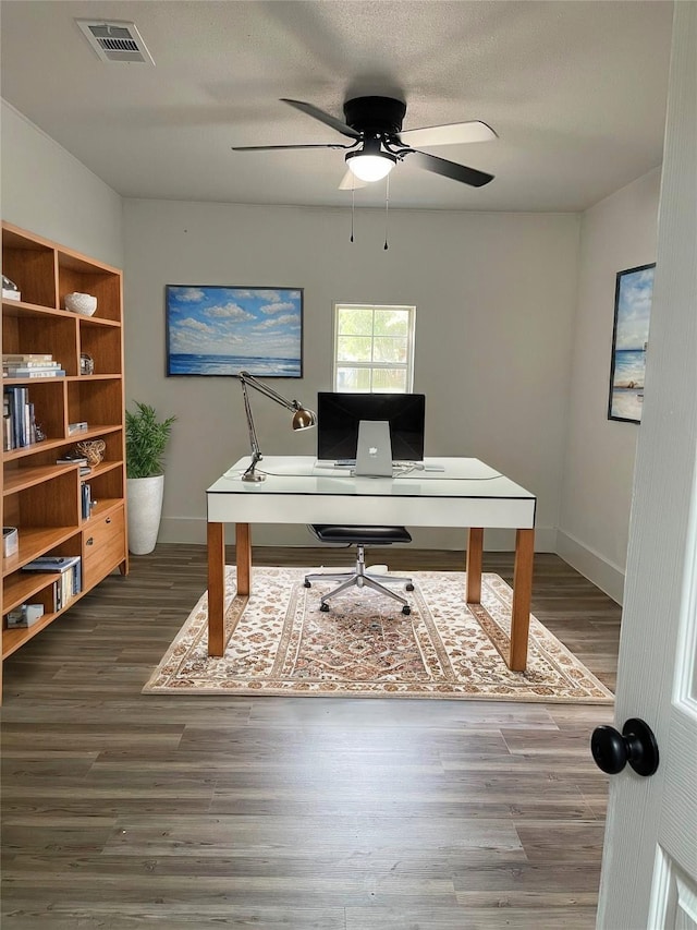 office space with a textured ceiling, ceiling fan, and dark wood-type flooring