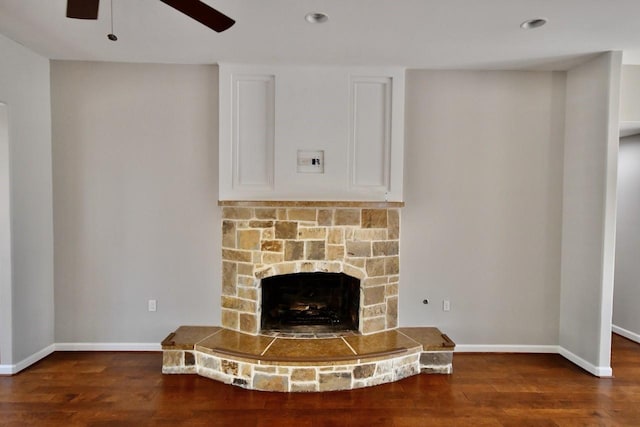 unfurnished living room with a fireplace, ceiling fan, and dark hardwood / wood-style flooring