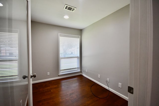 unfurnished room with dark wood-type flooring