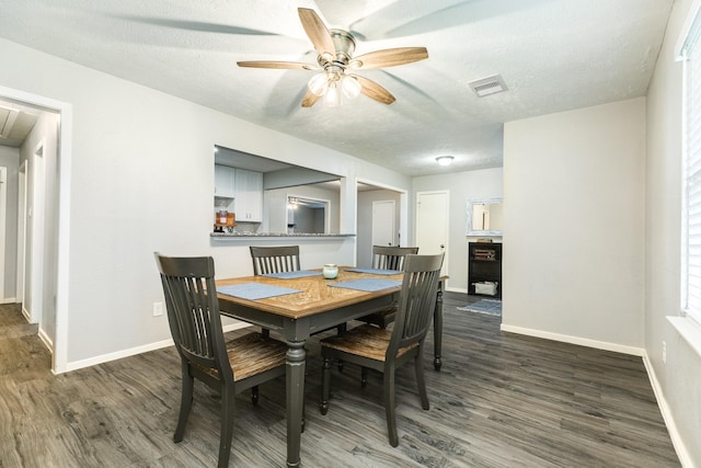 dining space with dark hardwood / wood-style floors, ceiling fan, and a textured ceiling