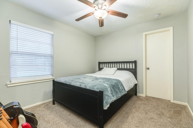 bedroom with multiple windows, ceiling fan, and light carpet