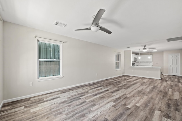 unfurnished living room with ceiling fan and light hardwood / wood-style floors