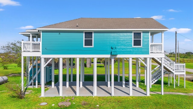 back of house with a yard, a patio, a shed, and a carport