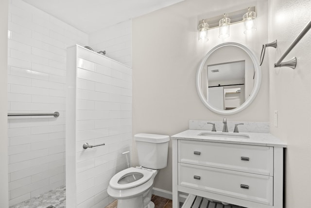 bathroom featuring tiled shower, vanity, and toilet