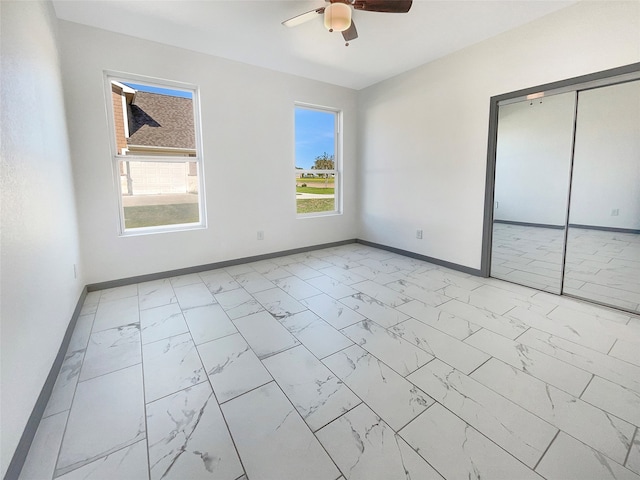 unfurnished bedroom featuring ceiling fan and a closet