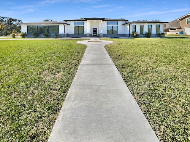 145 Birdie Dr, Hempstead, TX 77445 - view of front of home with a front yard and stucco siding