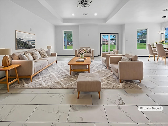 145 Birdie Dr, Hempstead, TX 77445 - living room featuring marble look tiles, a tray ceiling, and recessed lighting
