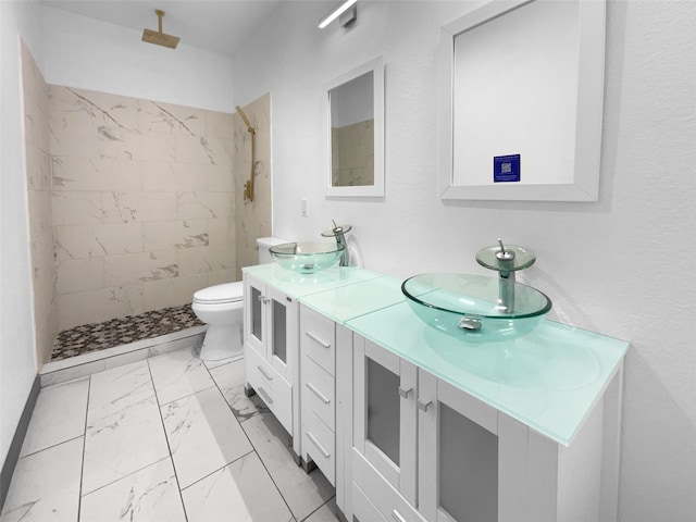 145 Birdie Dr, Hempstead, TX 77445 - bathroom featuring marble finish floors, double vanity, a tile shower, and toilet