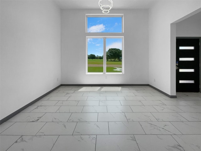 145 Birdie Dr, Hempstead, TX 77445 - unfurnished room with light marble finish floors, baseboards, and healthy amount of natural light