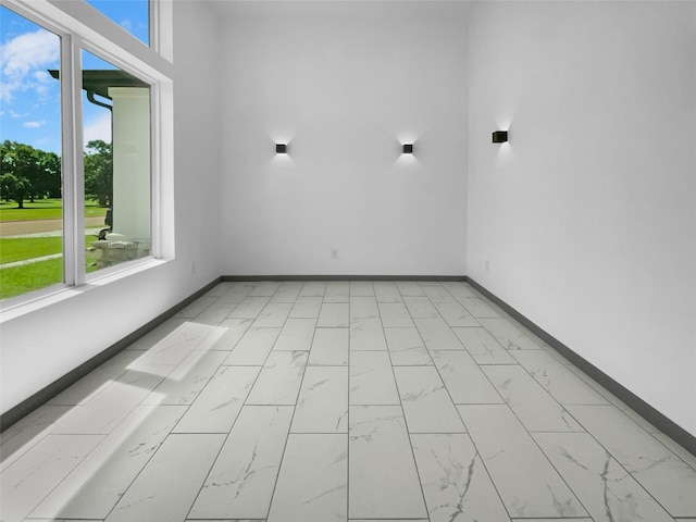 145 Birdie Dr, Hempstead, TX 77445 - empty room with healthy amount of natural light, light marble finish flooring, and baseboards
