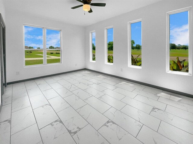 145 Birdie Dr, Hempstead, TX 77445 - spare room featuring light marble finish floors, a ceiling fan, and baseboards