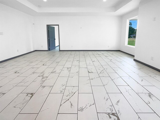 145 Birdie Dr, Hempstead, TX 77445 - empty room with a tray ceiling, baseboards, light marble finish floors, and recessed lighting