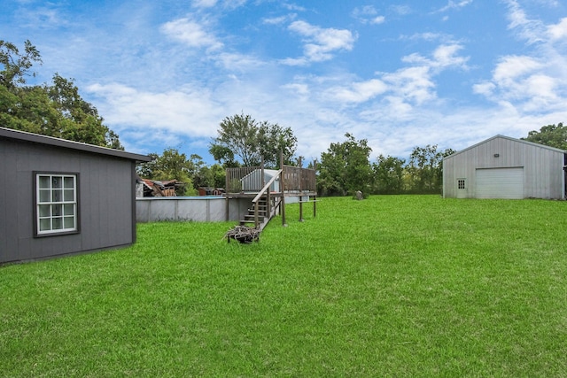 view of yard with a garage and an outbuilding