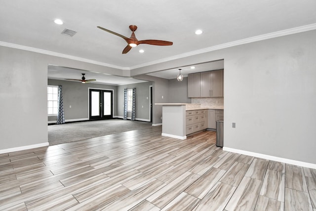 unfurnished living room featuring ceiling fan, crown molding, and french doors