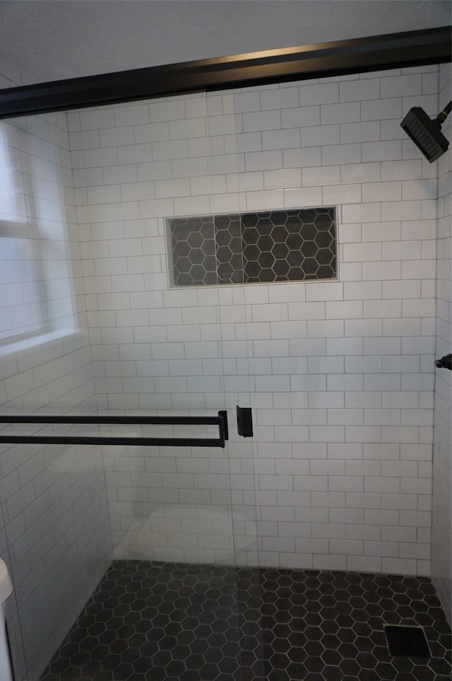 bathroom featuring tile patterned floors and a shower with door